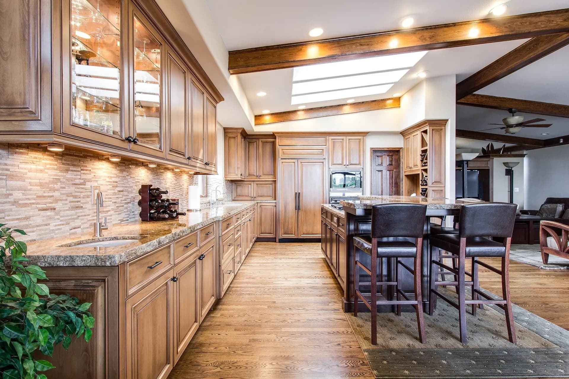 Kitchen with wooden cabinets, stone counters and bar stools